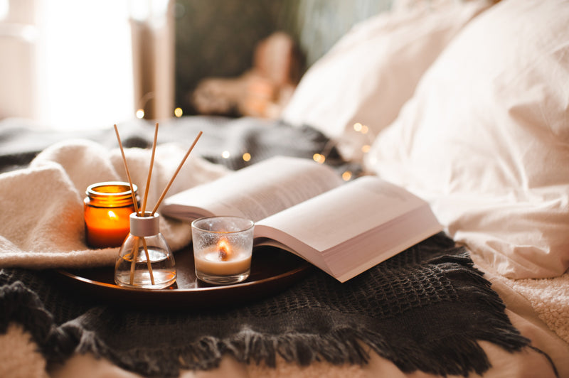 A book and soft bedside lighting creating a calm evening wind-down setting.
