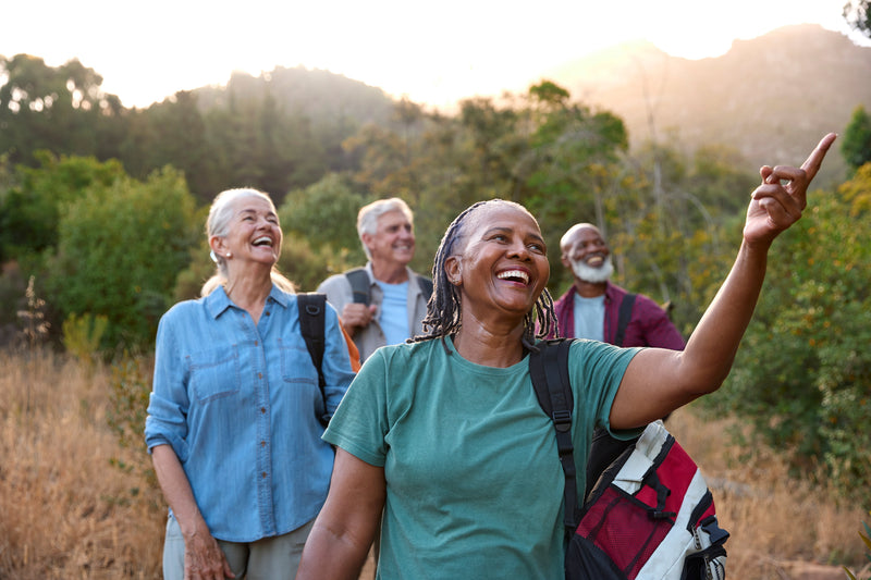 A group of older adult friends hiking together outdoors in nature.